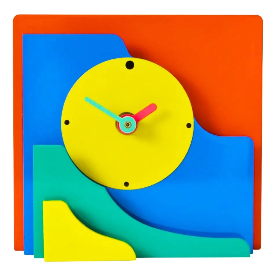 Layered Wall Clock: Memphis-style clock of overlapping orange, blue, green and yellow acrylic shapes with a yellow dial