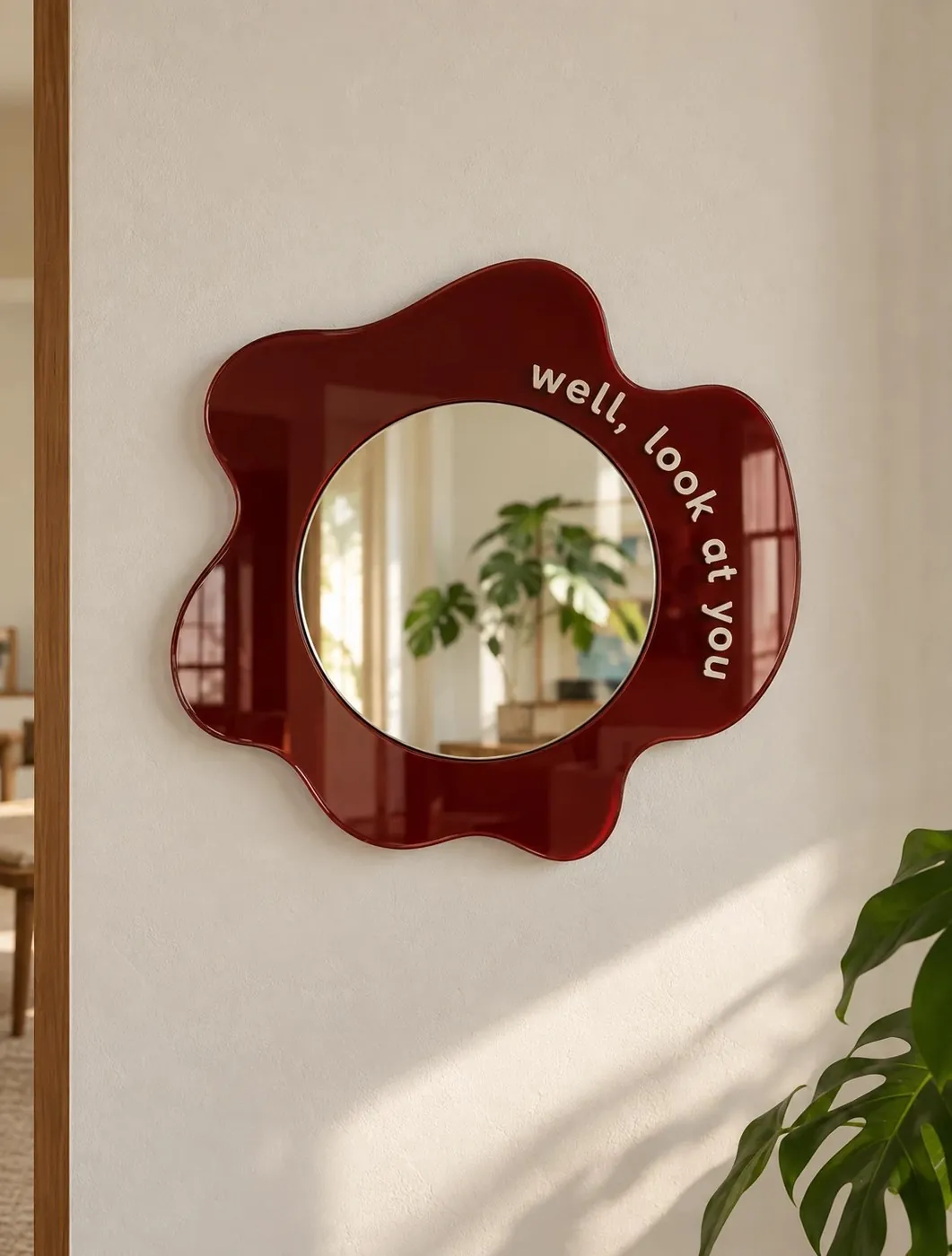 Well, Look At You: oxblood wavy mirror with “well, look at you” lettered around the rim