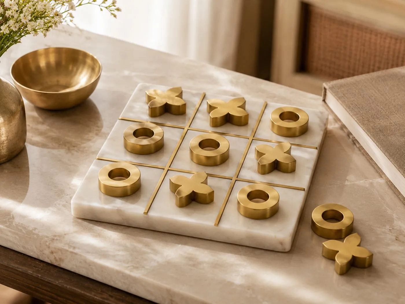 X + O: white marble noughts-and-crosses board with solid brass Xs and Os